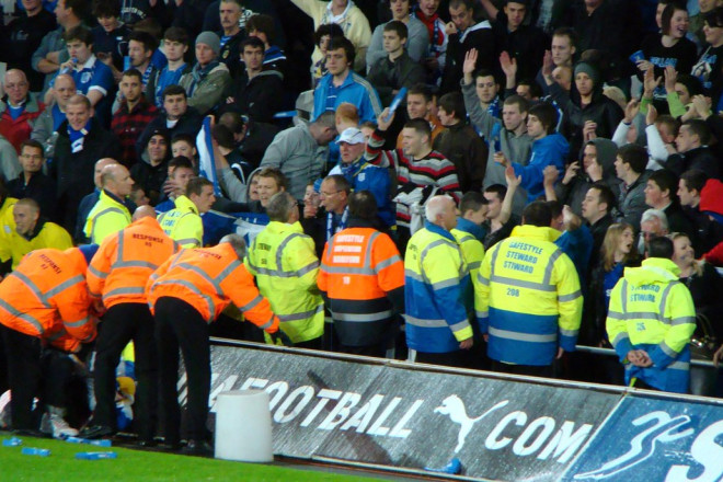 Des stewards canalisent des supporters dans un satde