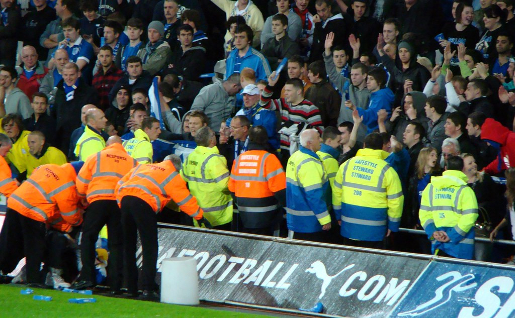 Des stewards canalisent des supporters dans un satde